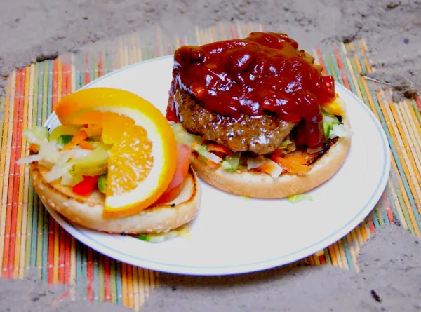 Hamburger met saus, salade en sinaasappel